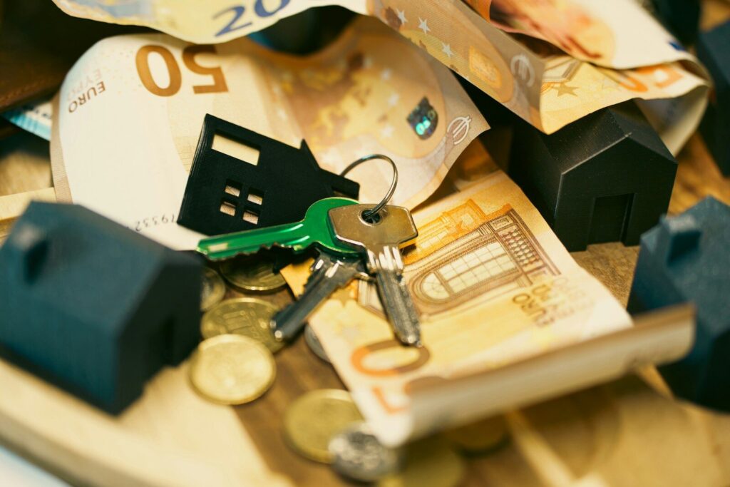 Money, keys, and miniature houses depict homeownership.